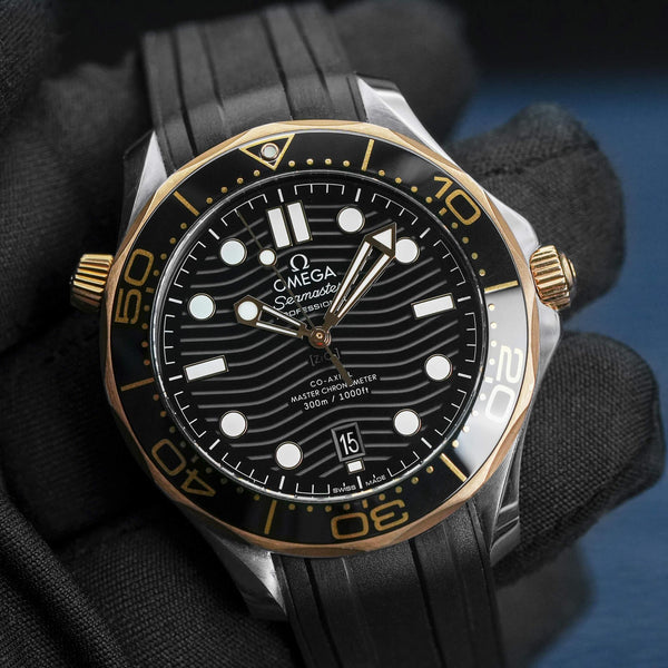 Front view of Omega Seamaster Diver 300M Black Dial Sedna Gold in gloved hand